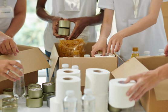Volunteers packing donation boxes with canned food and toiletries