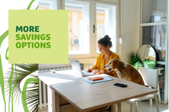 Woman sitting at a desk next to a window working on laptop with dog sitting next to her and headline "More Savings Options" overlayed.