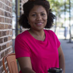 Woman sitting at coffee shop table smiling