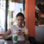 Woman on phone at coffee shop table