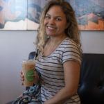 Smiling woman holding a cup of iced coffee