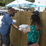 Man handing to-go food container to customer