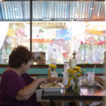 Woman sitting at restaurant table eating