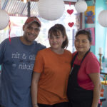 Two woman and man smiling for camera