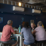 Group of four customers sitting at brewery table