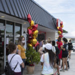 Customers waiting in line to enter building