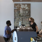 Sales clerk ringing up customer at coffee shop