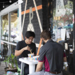 Two menu sitting at outdoor dining table eating