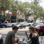 Man and woman sitting at outdoor dining table eating