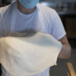 Man holding raw pizza dough