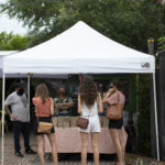 Group of young woman standing at farmers market tent