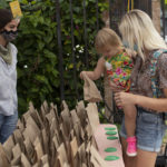 Mother and child looking at giftbags at farmers market table