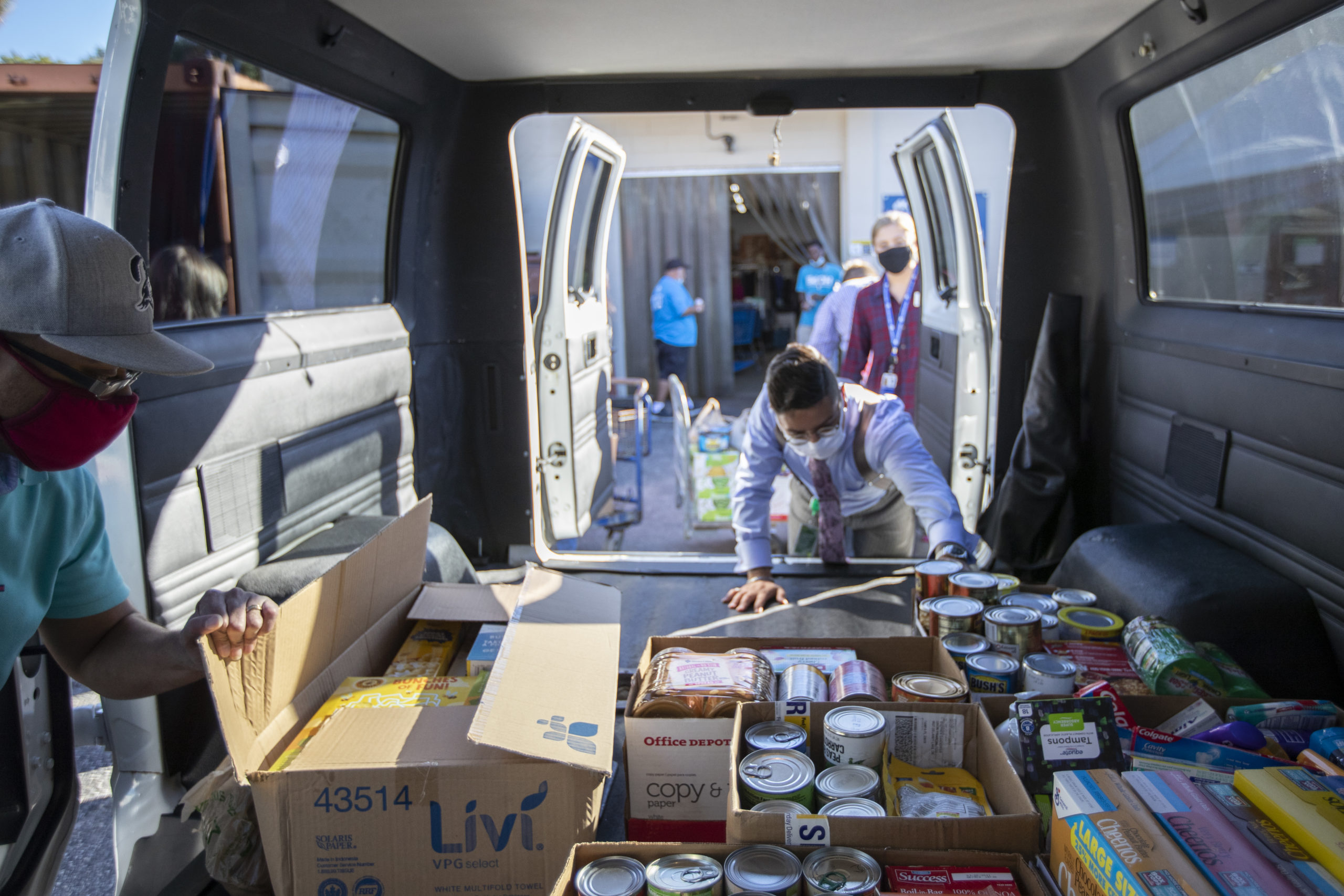 Grow Financial team members pack a vehicle with boxes of food donations after a collection drive