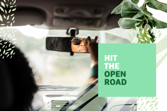 Person looking in the rearview mirror of a car with "Hit the Open Road" text overlayed