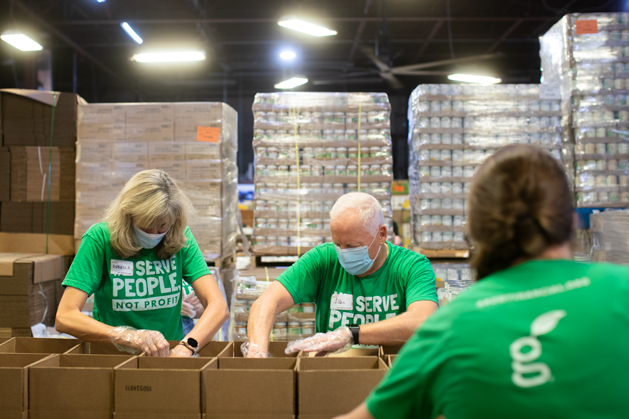 Grow team members serve the community by packing boxes of food at a food bank