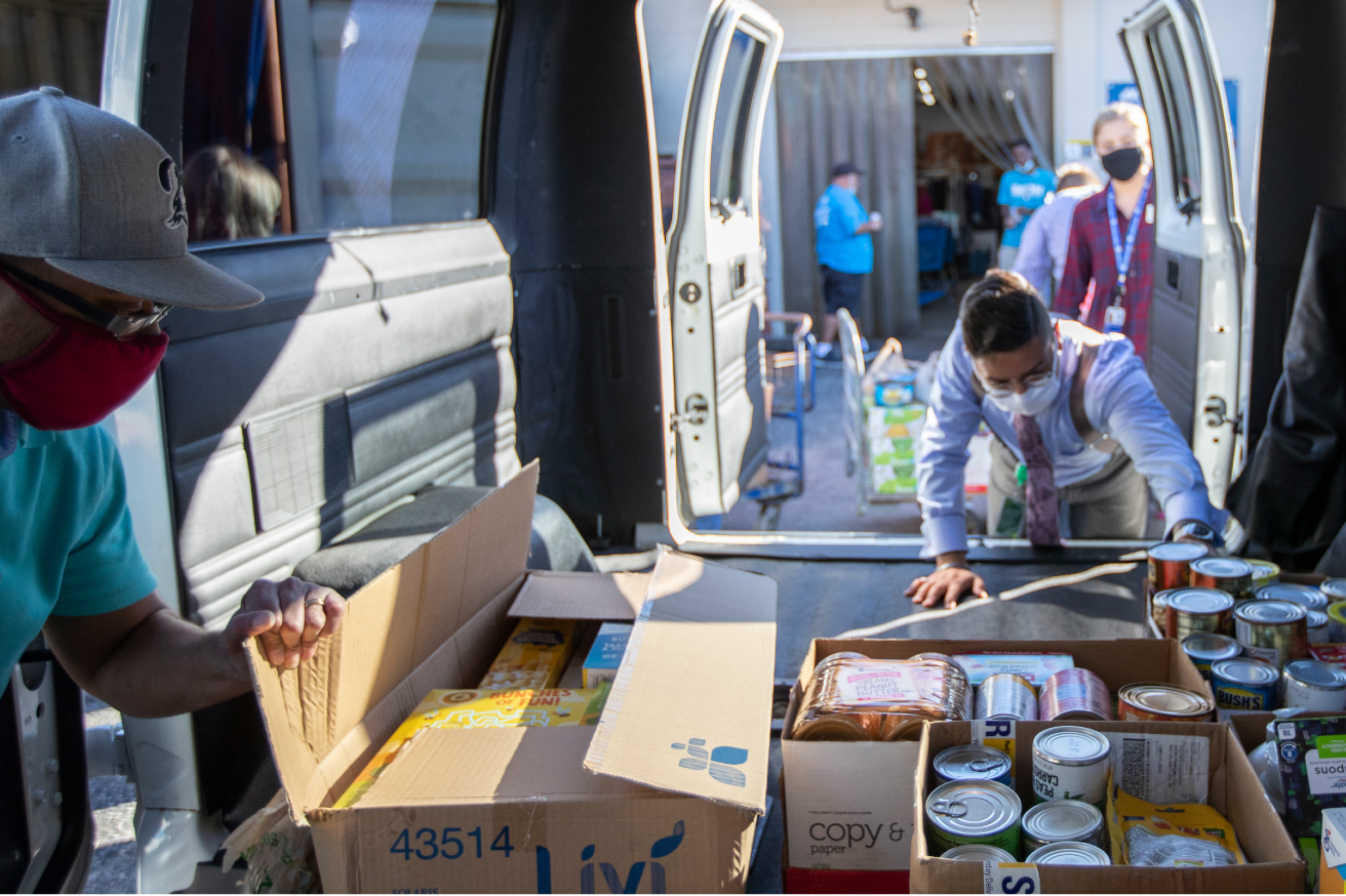 Team members load boxes of food into a van on a volunteer day