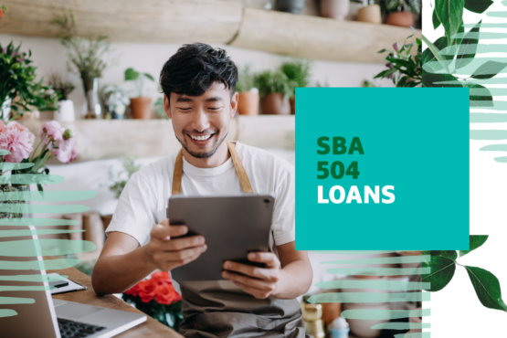 Man smiling while looking at an iPad with "SBA 504 Loans" text overlayed