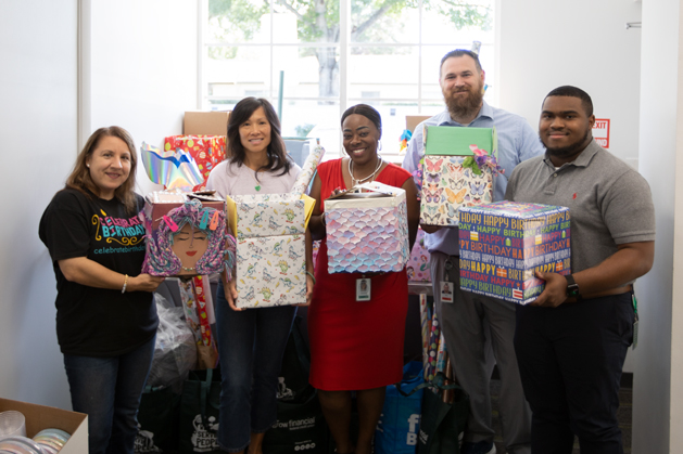 Grow Financial Foundation board members pose with donations supporting birthdays for foster kids