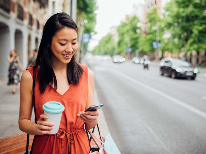Young woman looking at mobile device outside