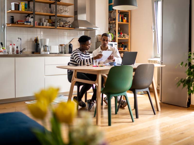 Male and female reviewing paperwork at kitchen table