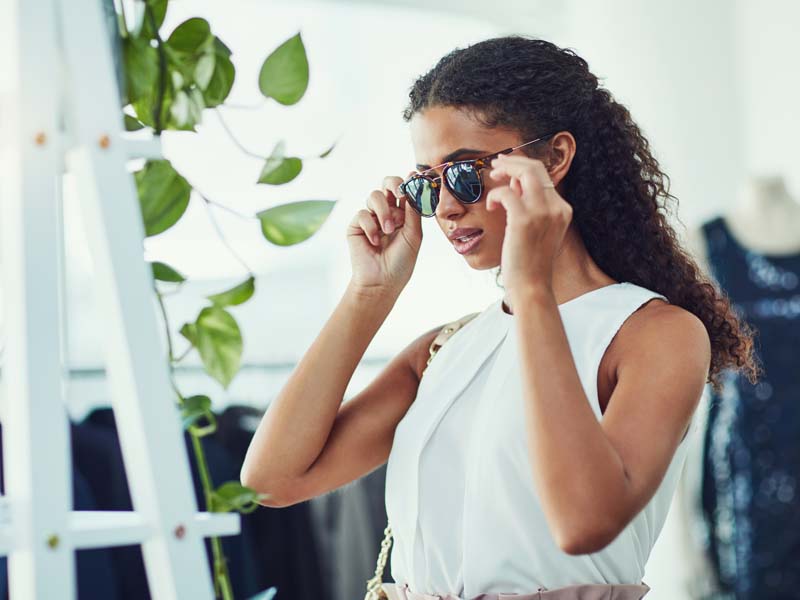 Woman trying on sunglasses in store