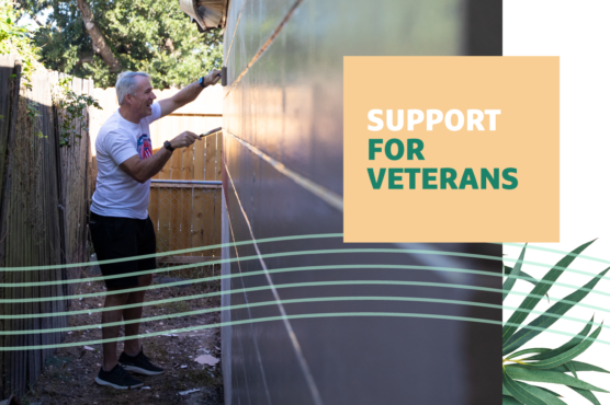 Grow team member paints a veteran's home during the Habitat for Humanity Veterans Build Week of Service with "Support for Veterans" text overlayed