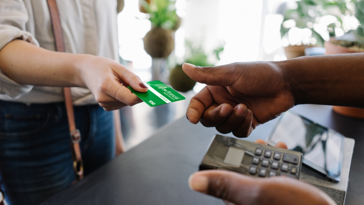 Woman handing a man a credit card to pay