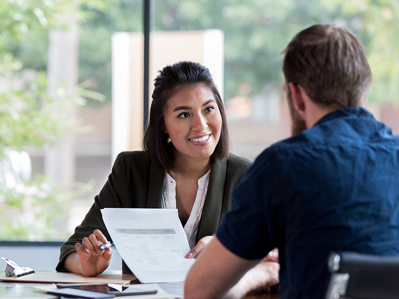 Woman and man sitting at desk reviewing paperwork