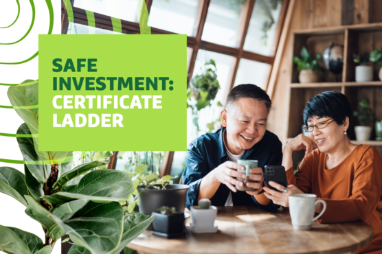 Man and woman sit at a table drinking coffee and looking at a phone while smiling with "Safe Investment: Certificate Ladder" text overlayed