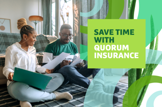 Woman and man sitting on the floor in front of couch reviewing insurance paperwork.