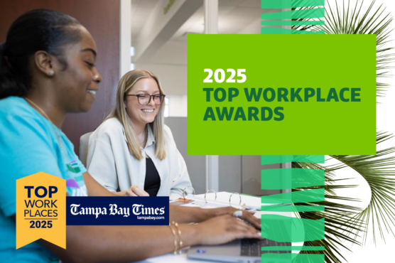 Two professionals smiling and working at a computer in an office, with a graphic announcing '2025 Top Workplace Awards' by Tampa Bay Times.