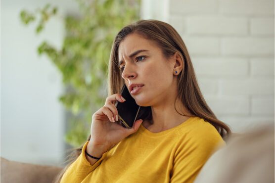 Woman looking distressed while on a phone call