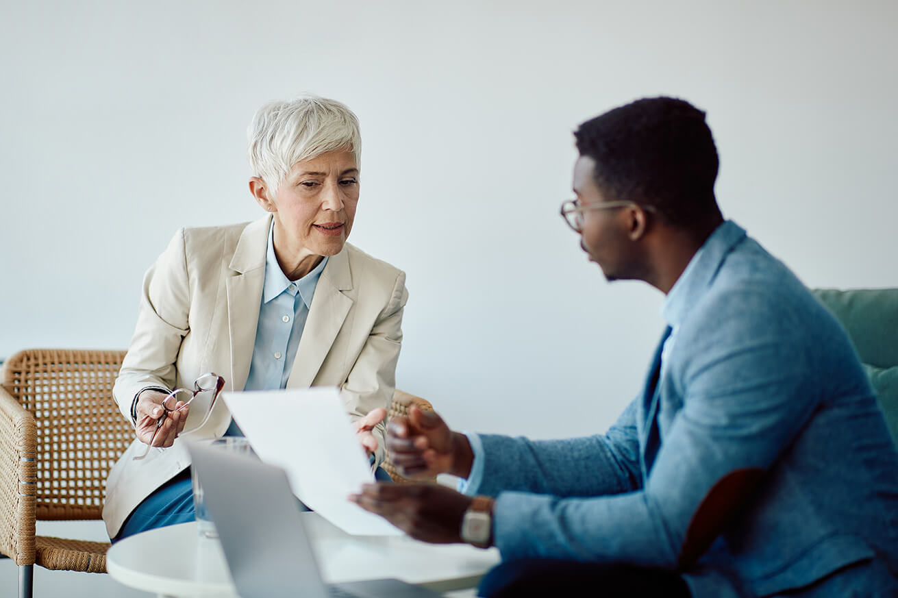 Male and female colleagues discussing while looking at a piece of paper