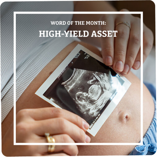 Pregnant woman holding print out of sonogram on her belly.